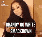 a woman is standing in front of a wall with the words `` brandy go write smackdown '' written on the screen .