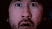 a close up of a man 's face with a surprised expression