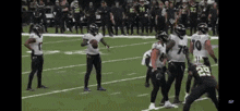 a group of football players are standing on a field and one of them has the number 29 on his jersey .