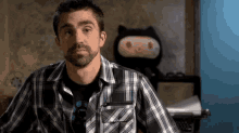 a man in a plaid shirt is looking at something