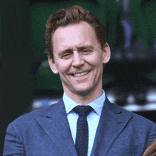 a man in a suit and tie is smiling