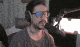 a man wearing glasses and headphones is speaking into a microphone that says blue on it