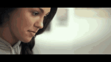 a close up of a woman 's face while looking down .