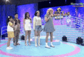 a group of people standing on a stage in front of a sign that says ' anghalan kids '
