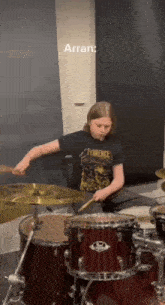 a man in a florence shirt plays the drums