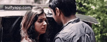 a man and a woman are standing next to each other in front of a car .