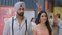 a man in a turban is standing next to a woman