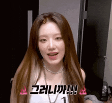 a close up of a woman with long hair wearing a necklace and a white tank top .