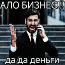 a man in a suit and tie is talking on a cell phone and waving .