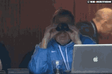 a woman in a bikini is seen through binoculars with a sb nation logo in the corner