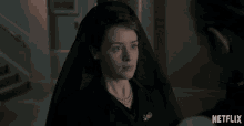 a woman in a black veil is standing next to a man in a suit with netflix written on the bottom