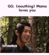 a man with long hair is smiling while standing in the woods with trees in the background .