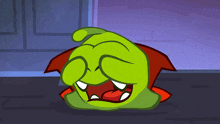 a green cartoon character with a red cape on covering his eyes