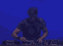a man in a black shirt is playing music on a pioneer mixer .