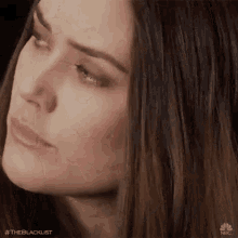 a close up of a woman 's face with her eyes closed and her hair blowing in the wind .