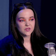 a close up of a woman 's face with a microphone in the foreground