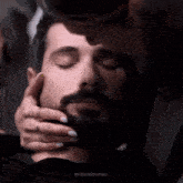 a woman is touching a man 's face with her hands
