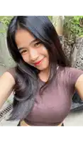 a woman in a brown crop top is smiling for the camera