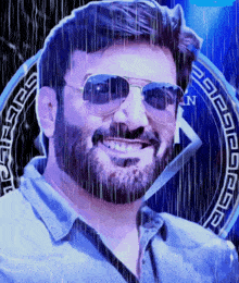 a man with a beard wearing sunglasses is smiling in front of a greek key emblem