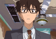 a man wearing glasses and a suit is looking at the camera