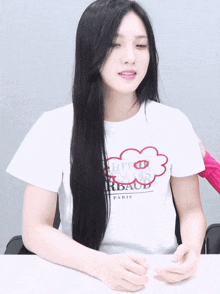 a woman wearing a white t-shirt that says paris on it