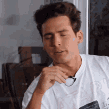 a man wearing glasses and a white shirt that says atari on it