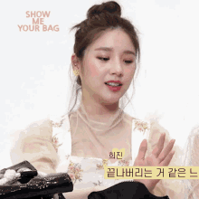 a woman in a floral apron is holding a black bag and the words show me your bag are behind her