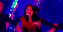 a woman is dancing on a stage in front of a crowd in a blurry photo .