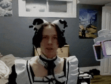 a man in a maid costume is wearing headphones and a bow tie