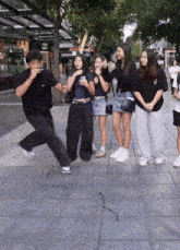 a group of people standing on a sidewalk in front of a store that says 000