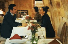 a man and a woman are sitting at a restaurant table
