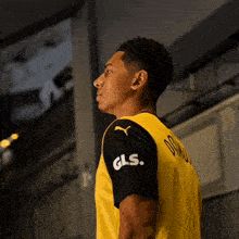 a man wearing a yellow and black shirt with gls on the sleeves