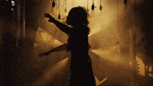 a silhouette of a woman in a dark room