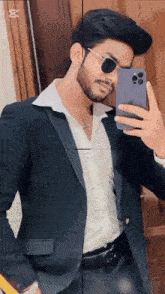 a man in a suit and sunglasses takes a selfie