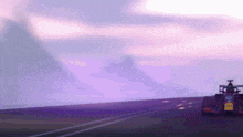 a race car is driving down a road with a purple sky behind it