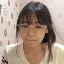 a young girl wearing glasses and a white shirt