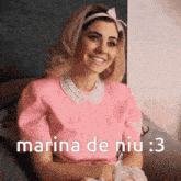 a woman wearing a pink shirt with the words marina de niu : 3 written on it