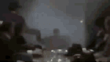 a blurry picture of a group of people sitting around a table in a dark room .
