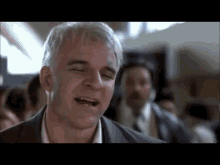 a man with white hair is singing in a crowd