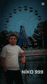 a man standing in front of a ferris wheel with niko 999 on the bottom