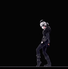 a man in a black suit is dancing in front of a black background with red lights .