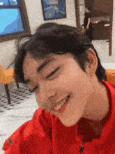 a close up of a person 's face with a red shirt on