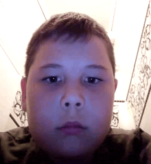 a close up of a young boy 's face with a purple background