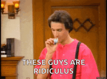 a man in a pink shirt is smoking a cigarette and says these guys are ridiculus
