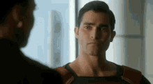 a man in a superman costume is standing next to a woman in a room .