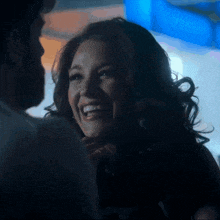 a woman is smiling and looking at a man