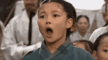 a young girl is making a surprised face in front of a crowd of people