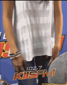 a woman is standing in front of a sign for kisfm