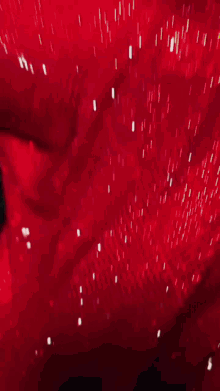 a woman in a red dress with white nails is sitting in a car