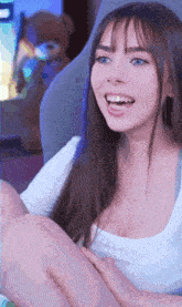a woman is sitting in a chair with her legs crossed and smiling at the camera .
